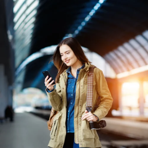 femme reservant transfert gare de mulhouse avec son telephone